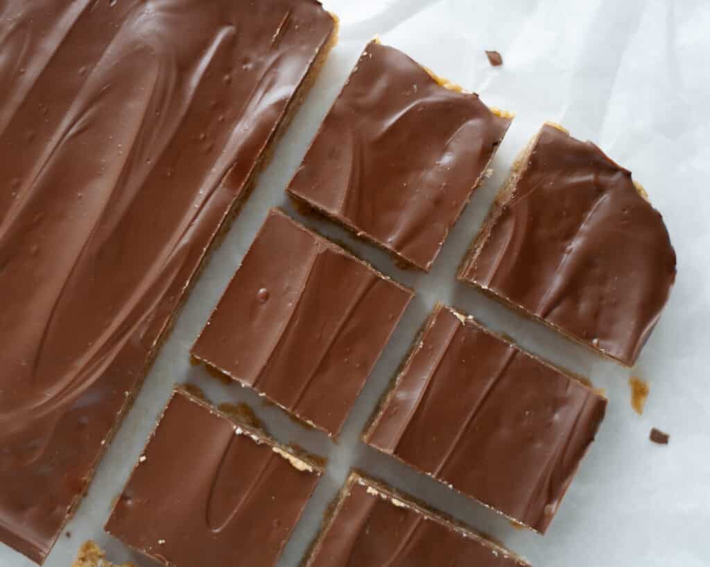 Top view of a pan of scotcheroo bars with half of them cut into squares