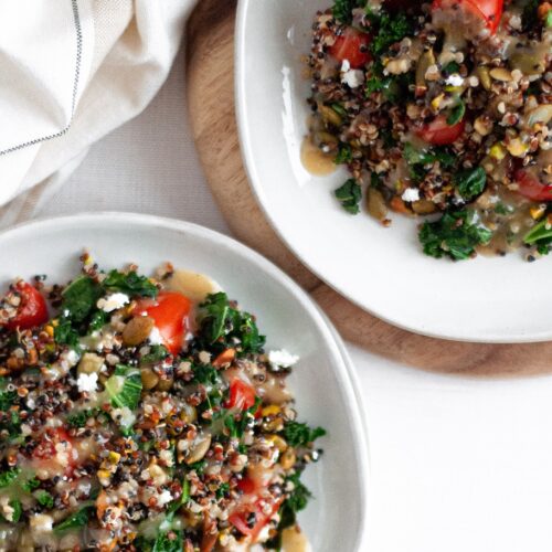 top down view of two plates filled with this Kale and Quinoa Power Salad recipe and topped with maple tahini dressing.