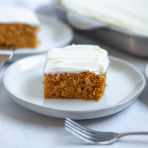 close up of a slice of pumpkin bar with cream cheese frosting.