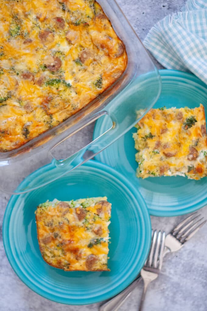 top down view of this egg bake recipe, showing the pan of this broccoli, cheese, and chicken sausage breakfast casserole and two plates with slices of egg bake ready to eat