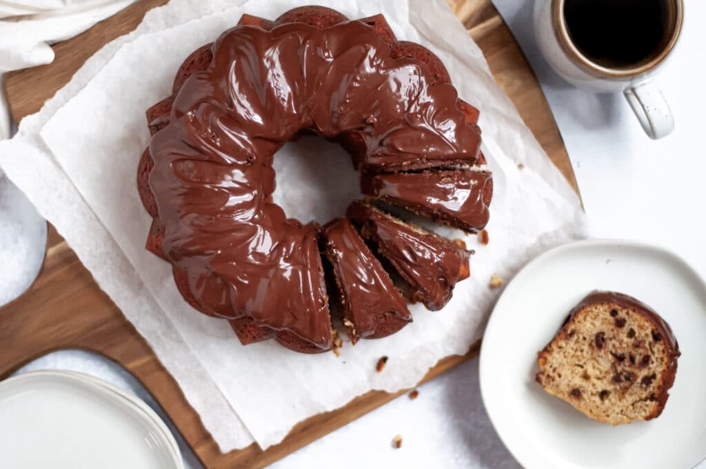 Top down view of a banana chocolate chip bundt cake with chocolate glaze, cut into 4 slices.