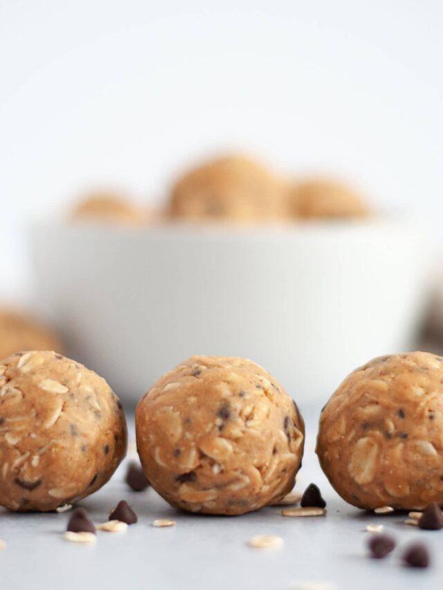 Close-up view of three protein energy balls with oats and chocolate chips.