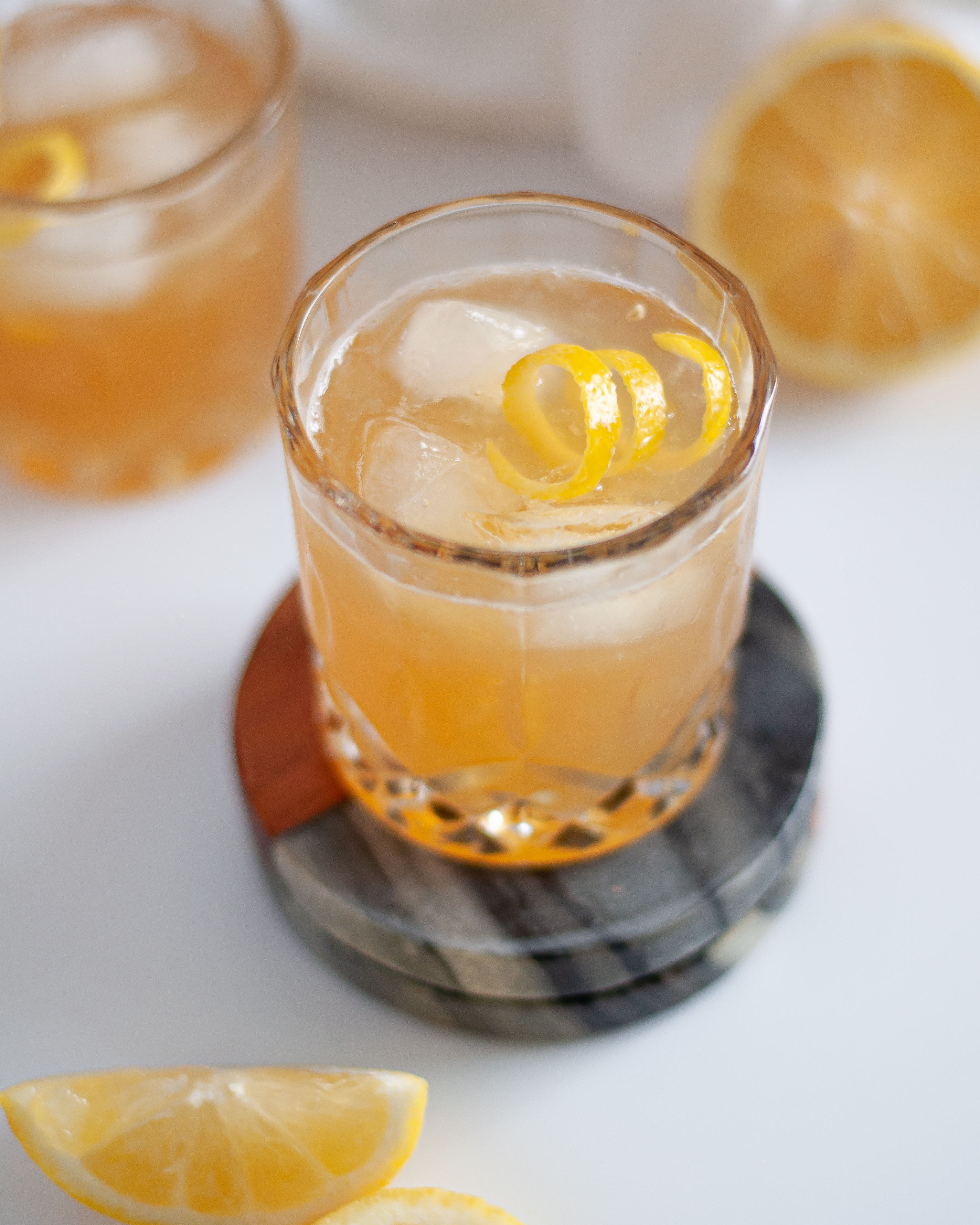 Gold Rush Cocktail served with ice and a lemon twist