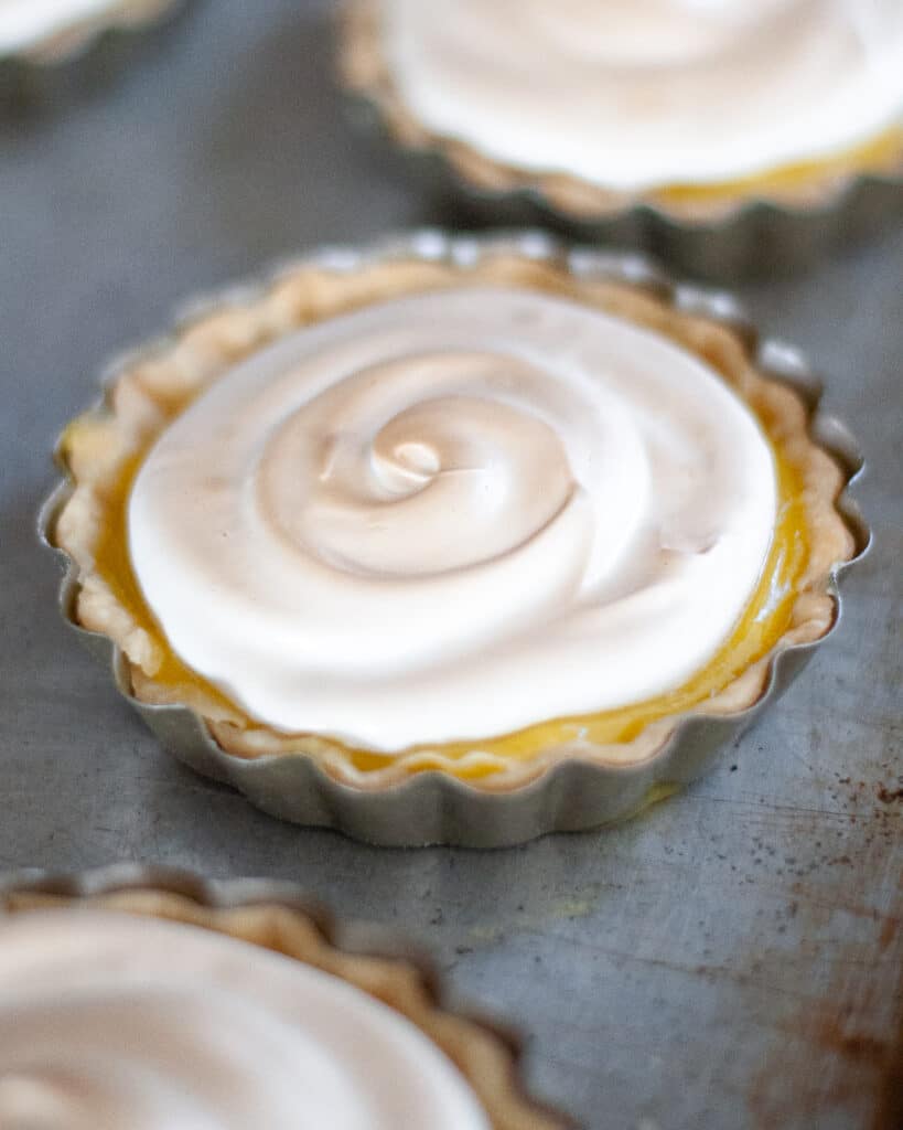 Close up of a mini lemon meringue tart after being toasted in the broiler.