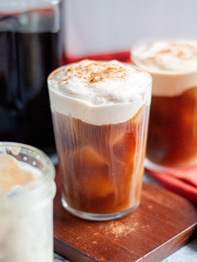 close up of a homemade pumpkin cream cold brew, topped with a generous amount of homemade pumpkin cold foam and additional pumpkin pie spice.