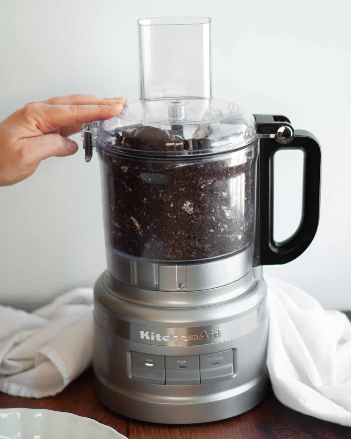 process shot showing how to make oreo balls. showing the oreo and cream cheese filling being mixed up in a food processor.