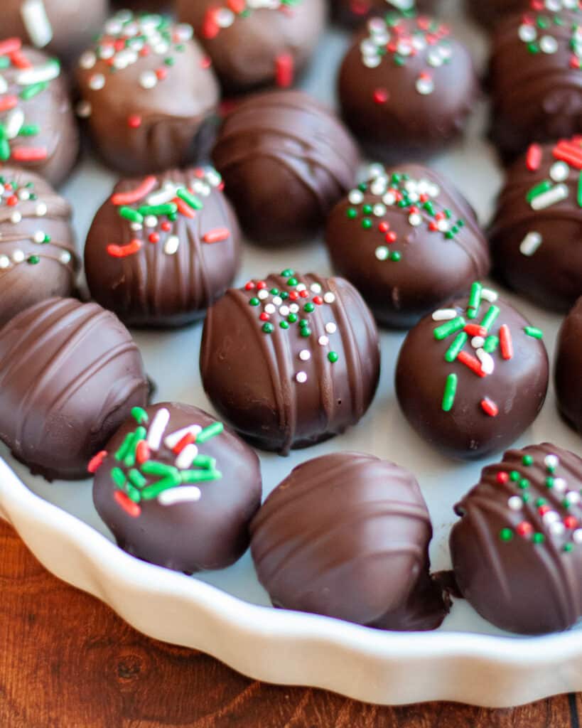 a white serving dish filled with holiday oreo truffles.