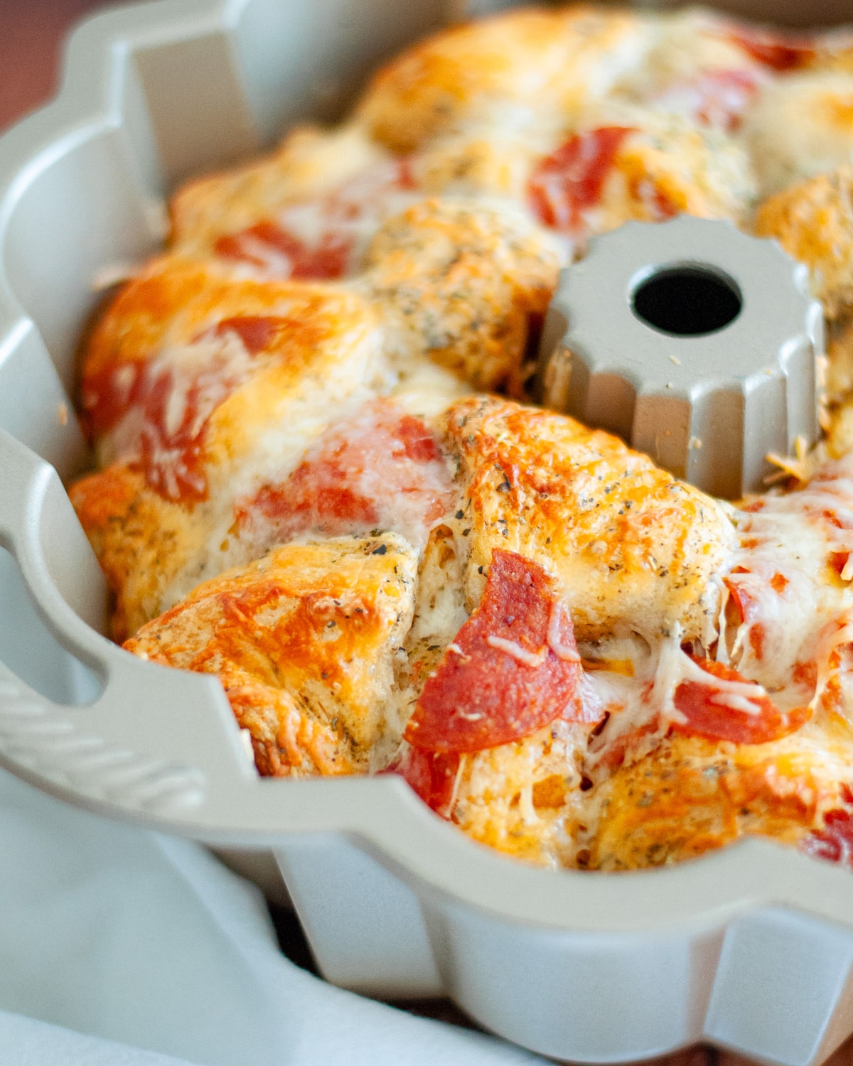 pepperoni pizza monkey bread fresh out of the oven. the dough is toasted to a perfect golden-brown, and the cheese is nice and melty.