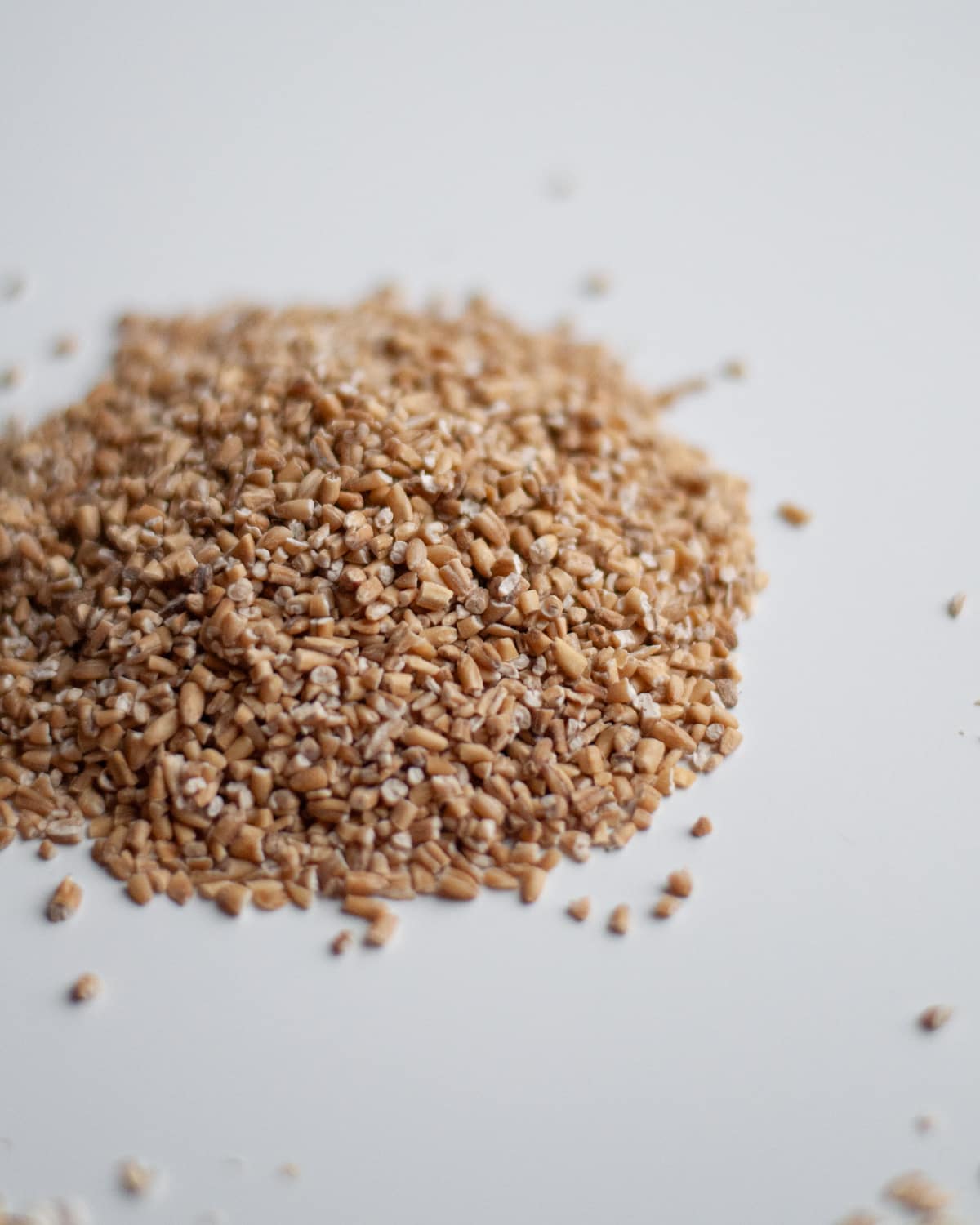 Close up of a pile of steel cut oats to show the shape and texture of the grain.