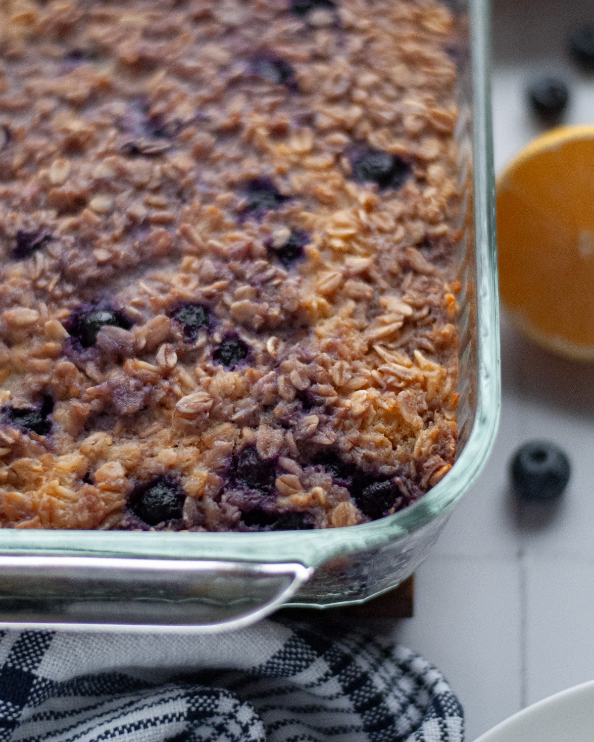 Glass 9x9 baking pan with a golden brown blueberry lemon baked oatmeal fresh out of the oven.