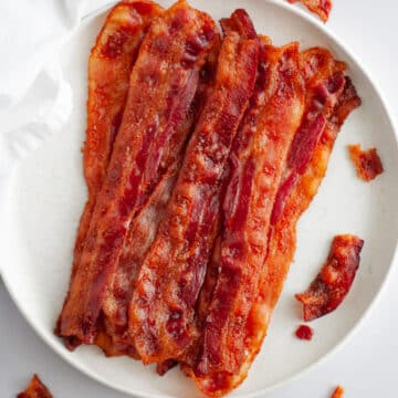 A plate full of crispy, evenly cooked bacon.