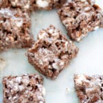 Cocoa pebbles treats cut into squares sitting in a 9x13 pan.