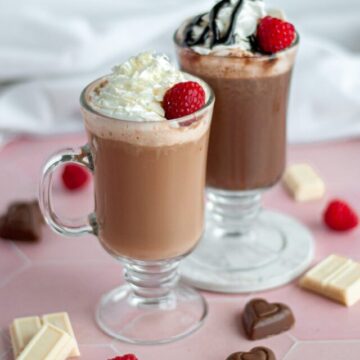 A white chocolate raspberry mocha and a dark chocolate raspberry mocha garnished and ready to drink.