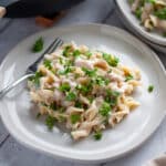 A serving plate with a hearty scoop of tuna casserole topped with parsley.