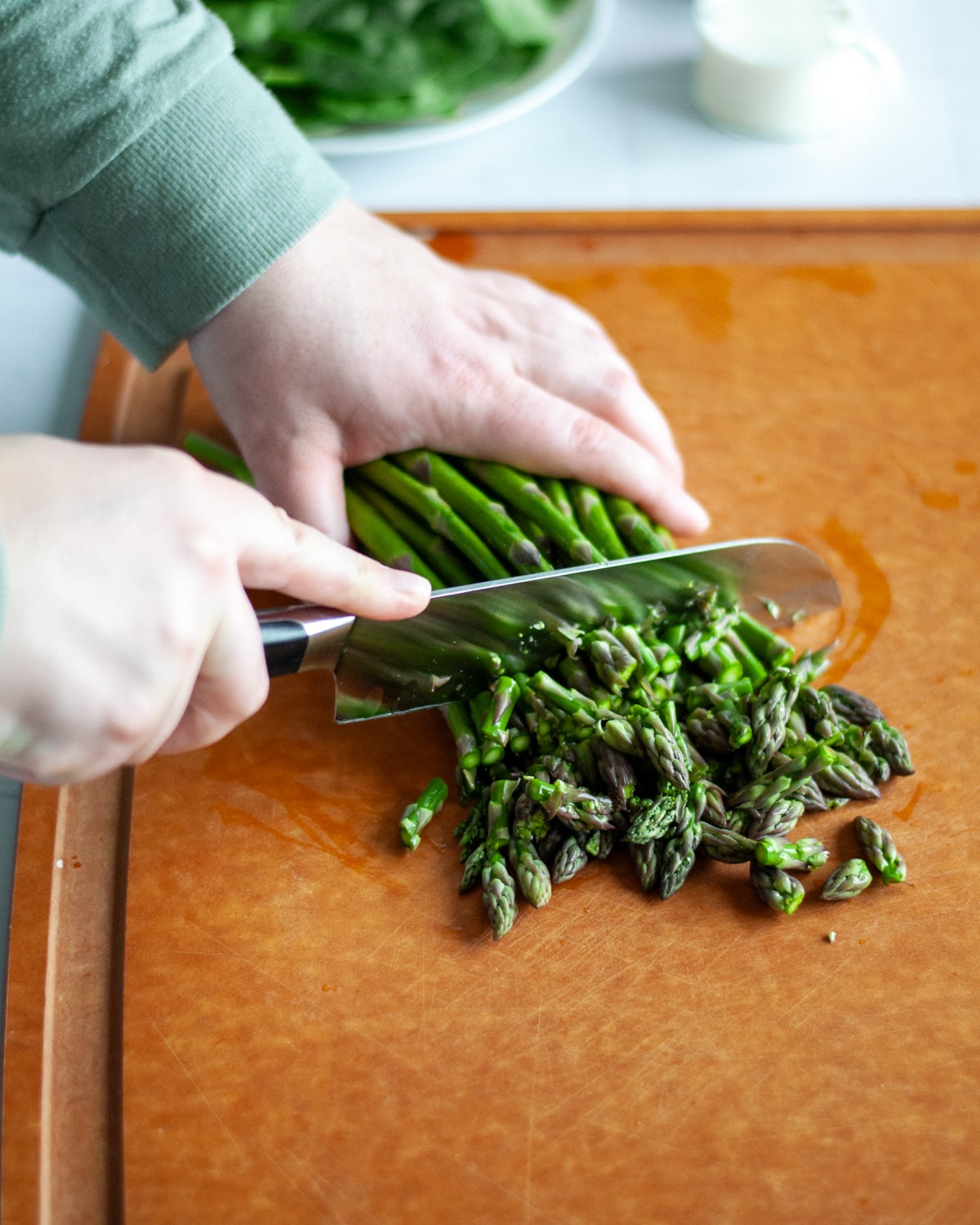 Process shot showing the asparagus being chopped.