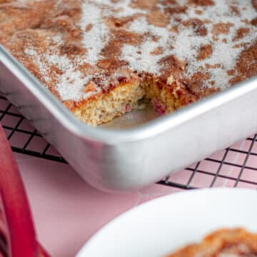 Close up showing the inside of the rhubarb cake in the pan where a slice is removed.
