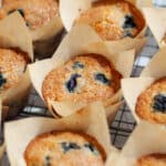 A batch of freshly baked blueberry muffins on a wire cooling rack.