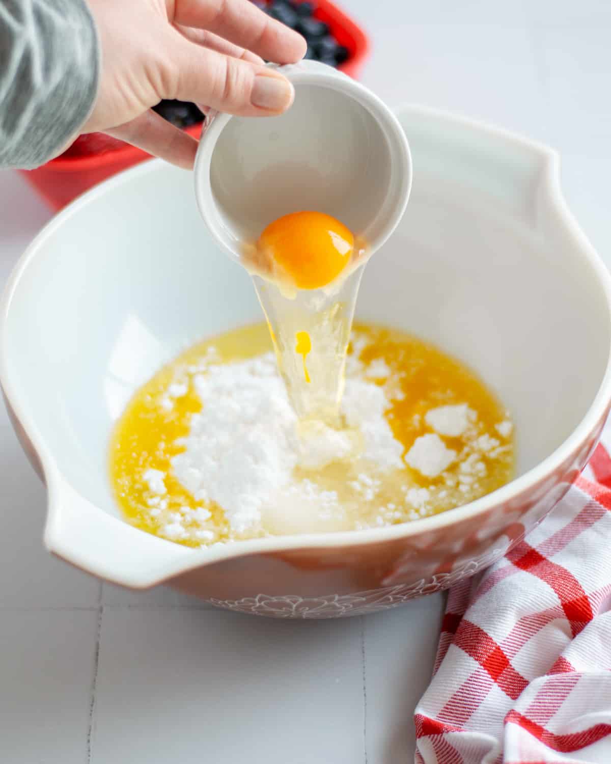 Process shot showing the crust wet ingredients and sugars being added to a large mixing bowl.