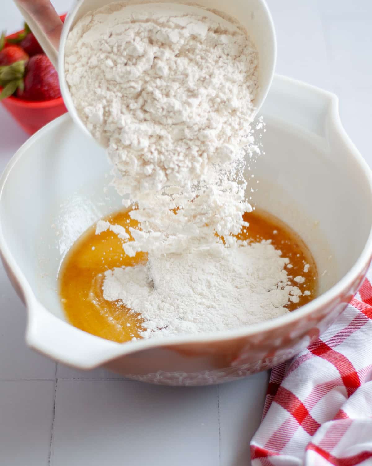 Process shot showing the sugar cookie crust dry ingredients being added to the bowl.