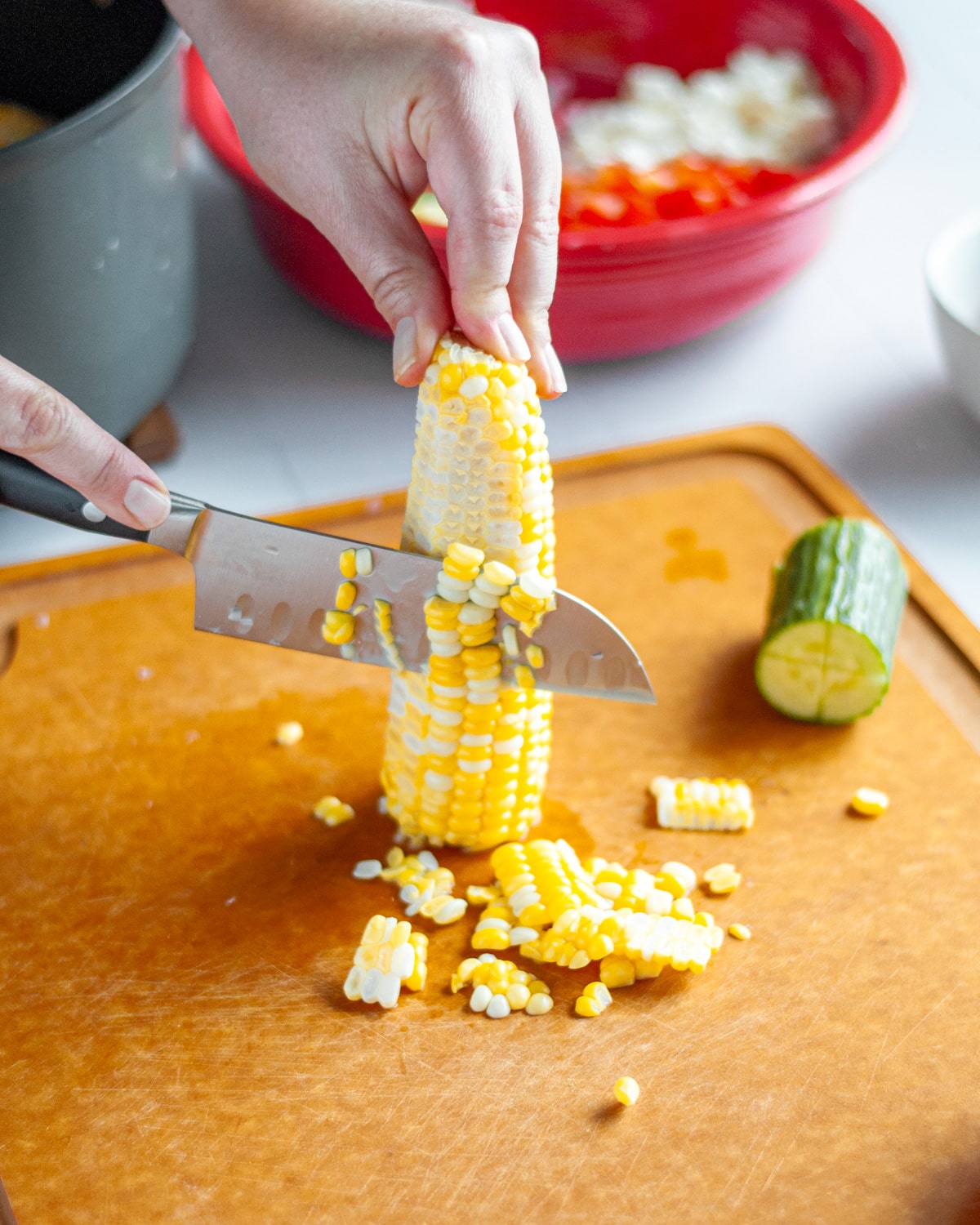 Process shot showing the corn being cut off the cob after cooking.