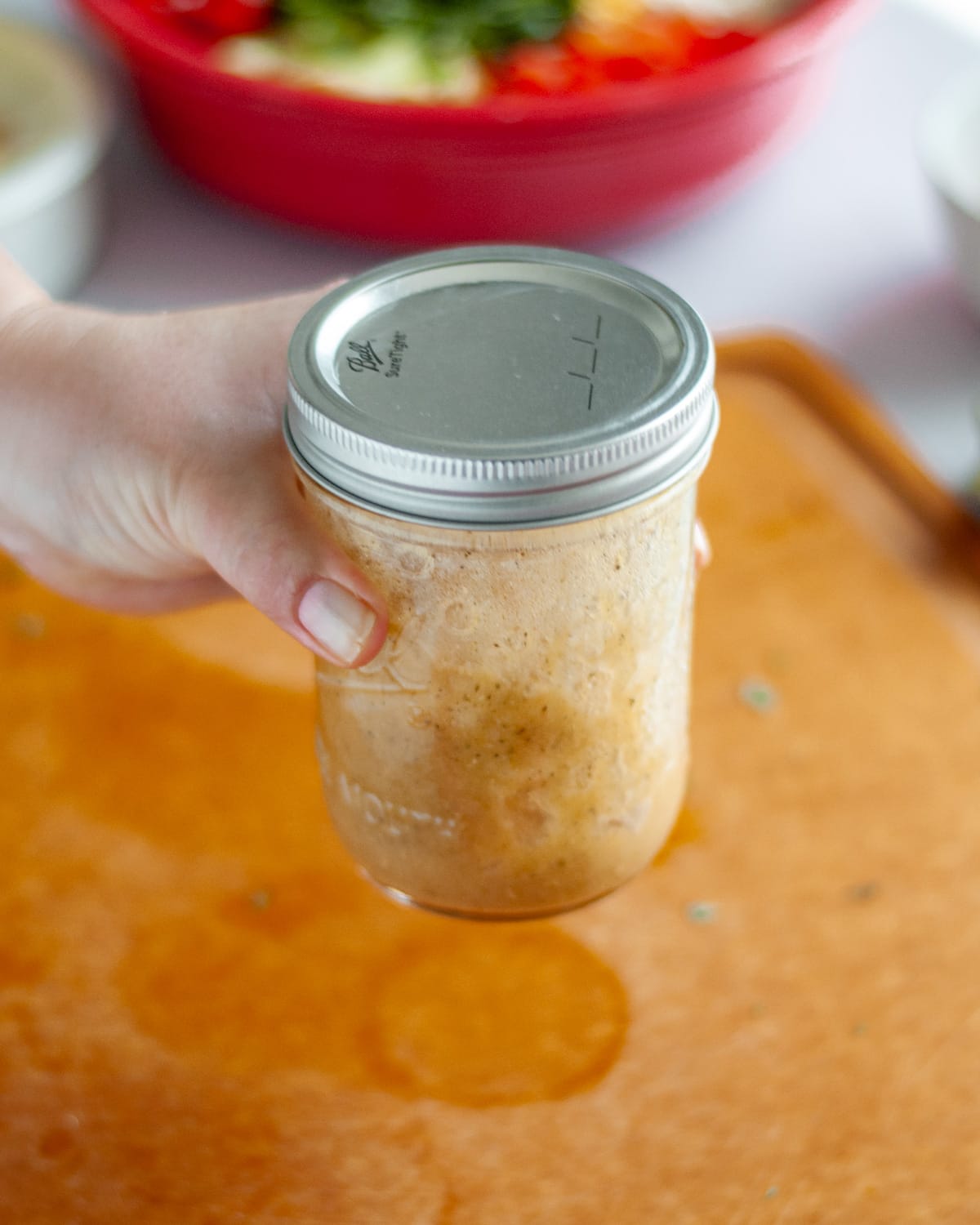 Process shot showing the dressing being shaken together in a jar.