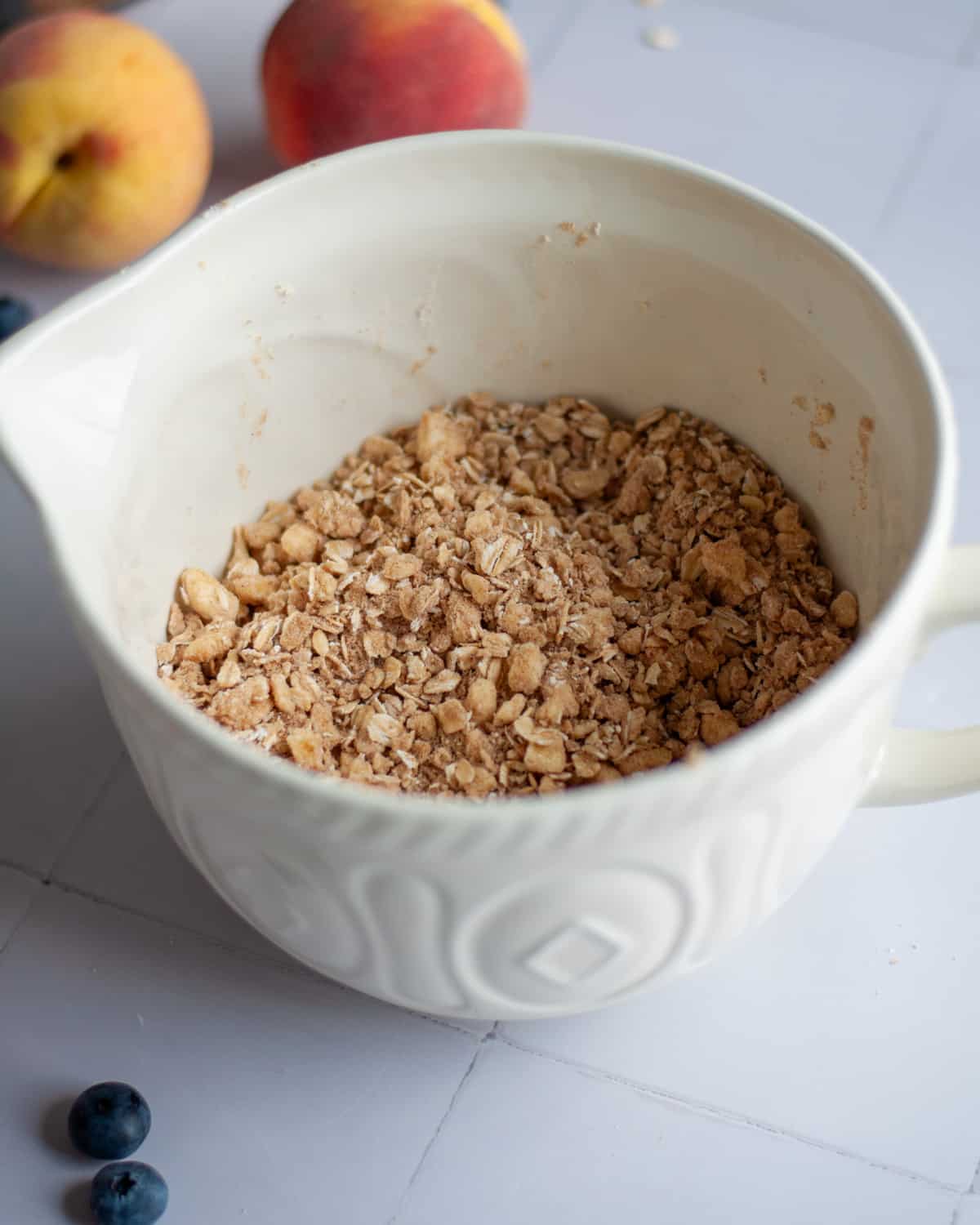Process shot showing the oatmeal topping mixture completed, with the cold butter cut into the rest of the ingredients.