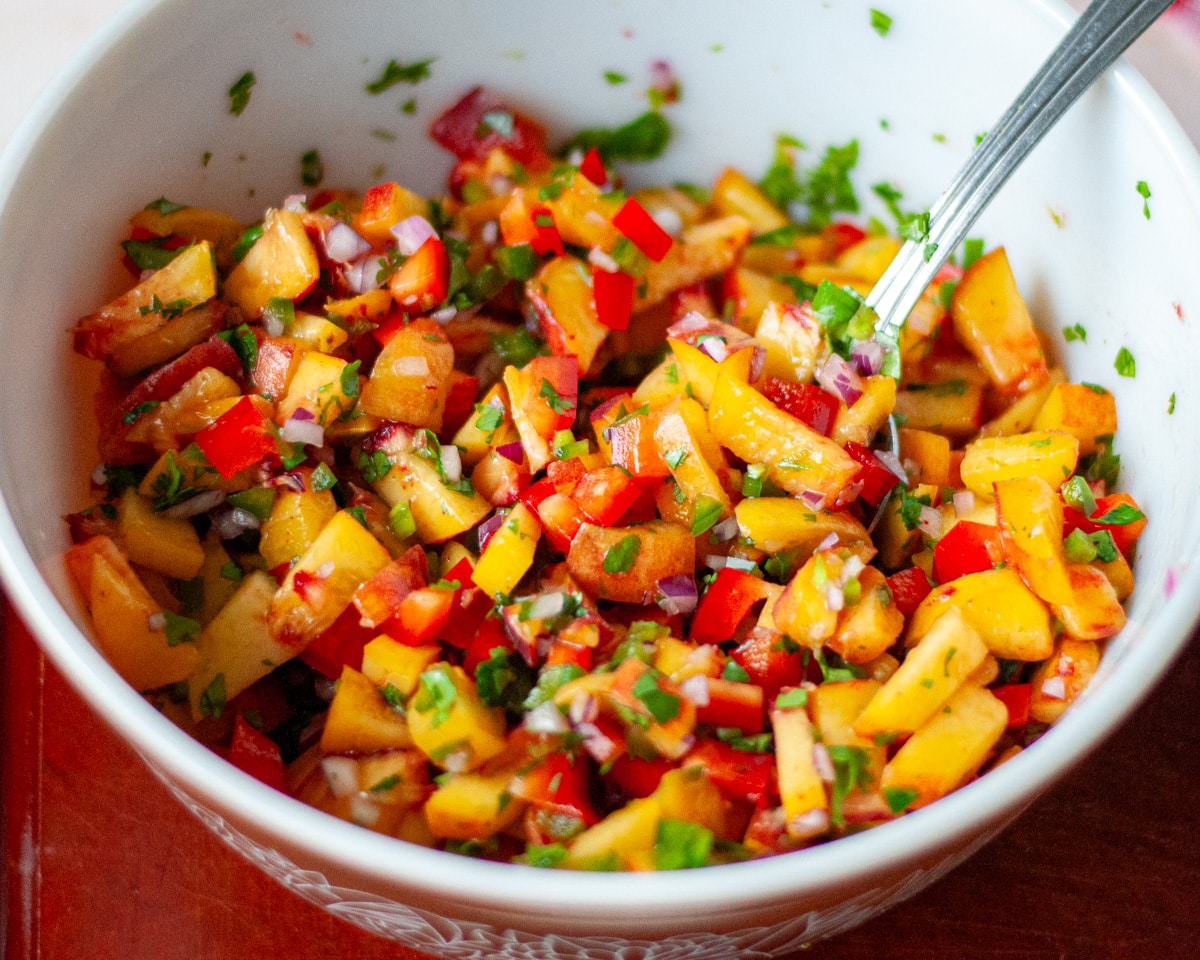 Close up of the fresh peach salsa in a large mixing bowl.