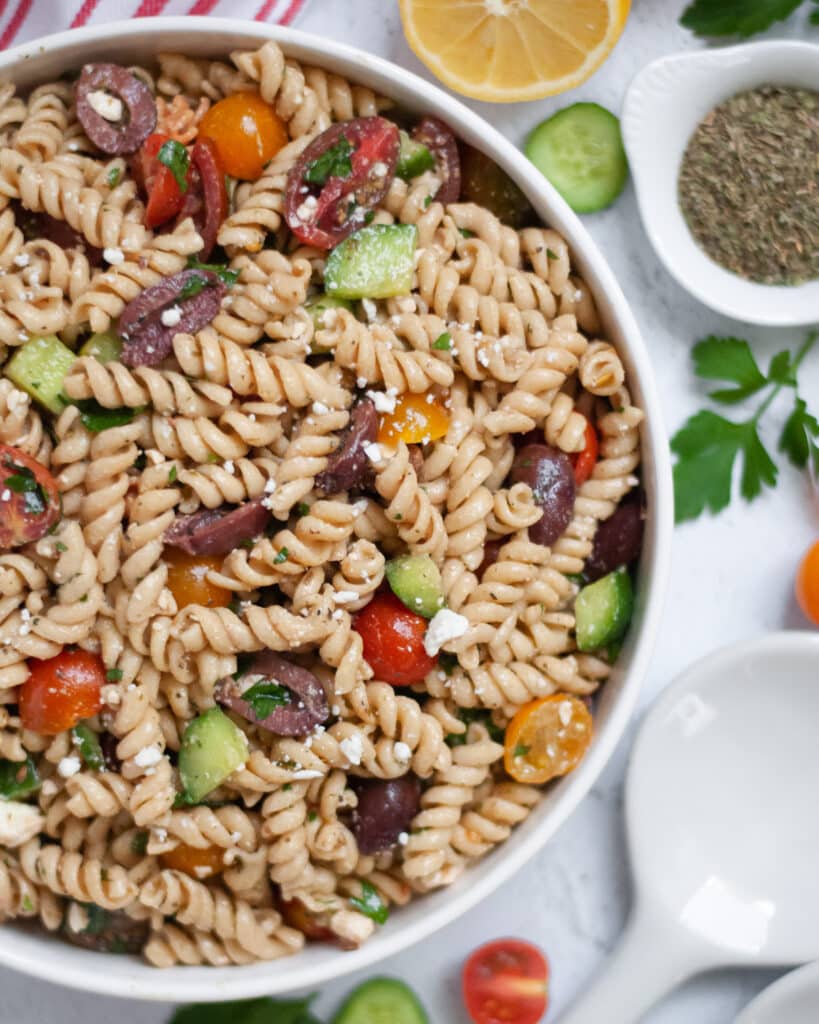 Top down shot of vegetarian Mediterranean Pasta Salad in a white serving bowl.