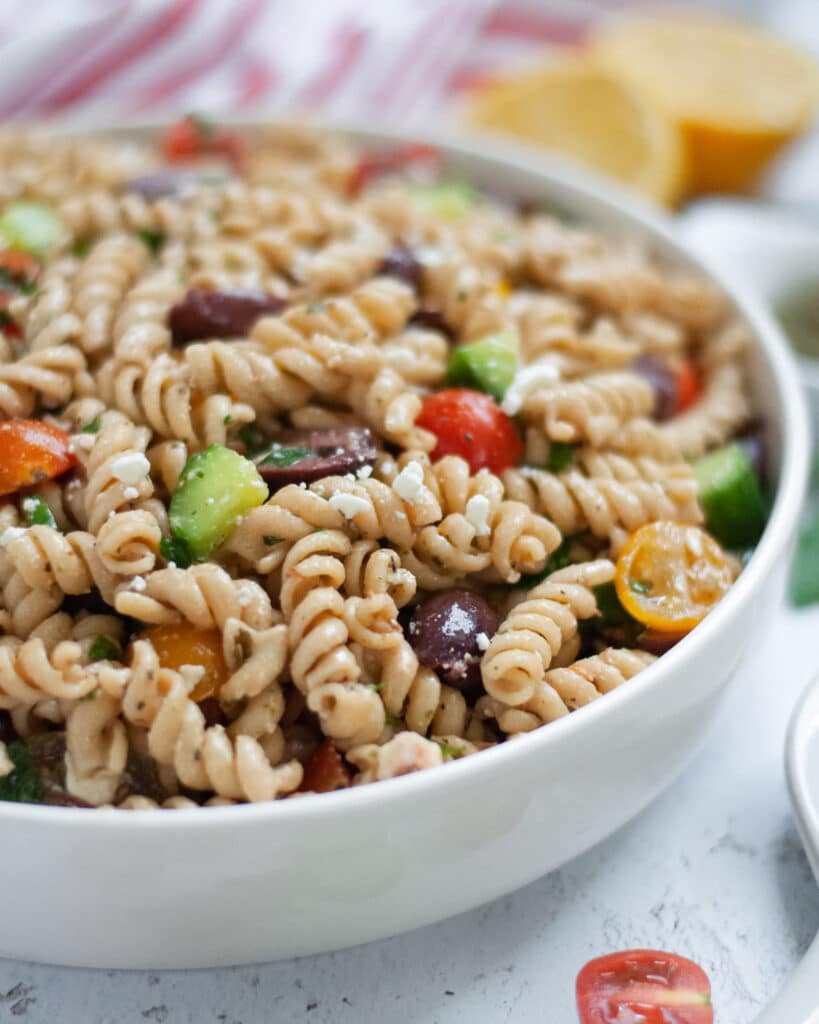Serving dish filled high with our cold Mediterranean pasta salad recipe.