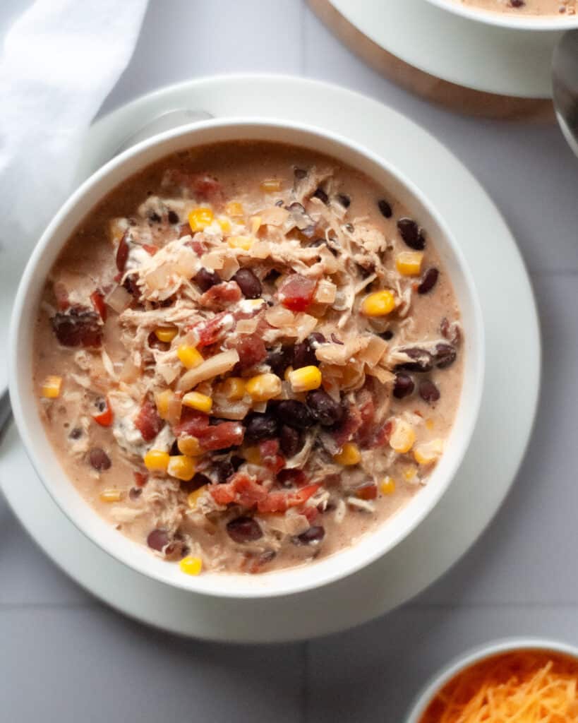 Top down view of a bowl of white chicken chili with bacon.