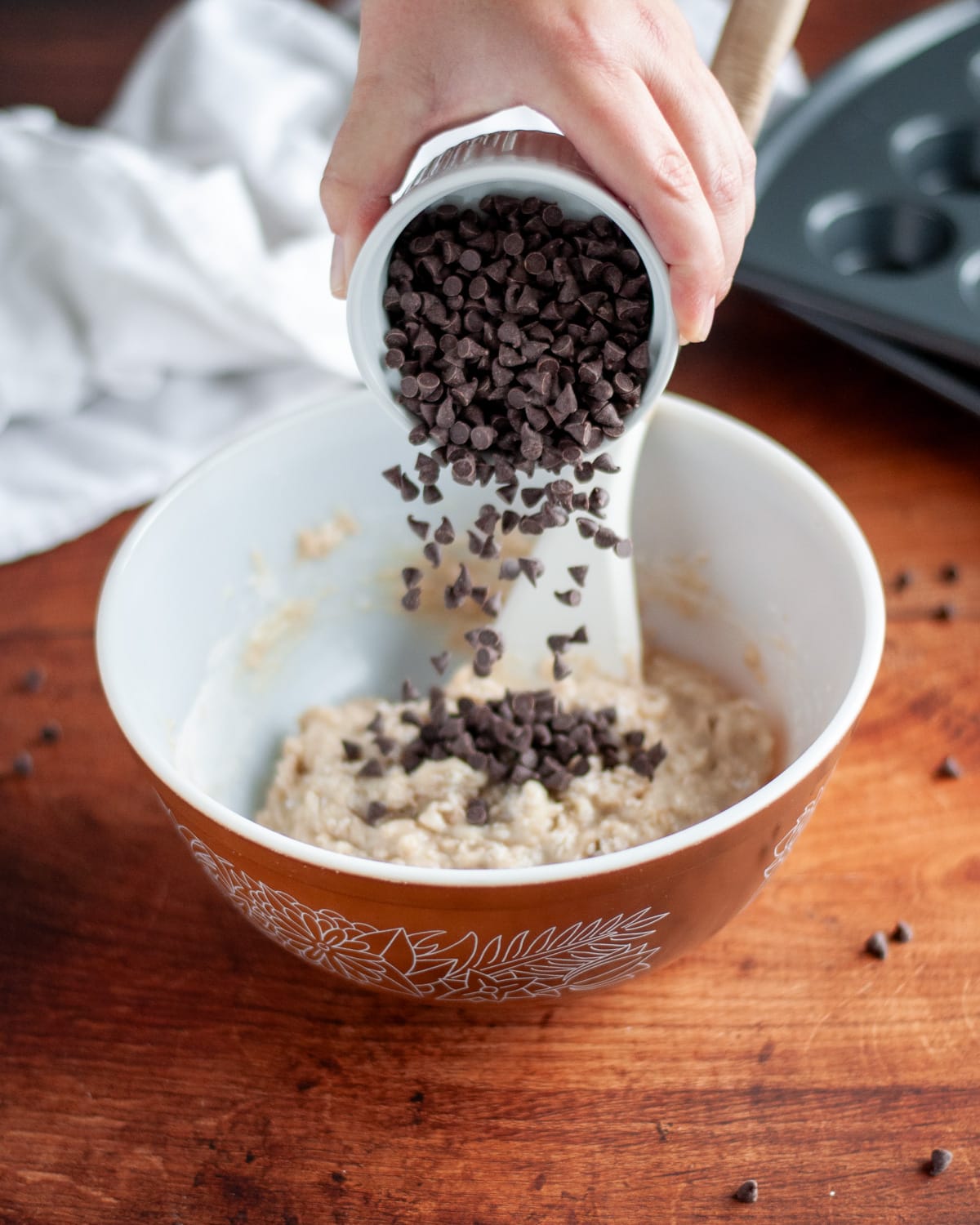Process shot showing the the mini chocolate chips being poured into the mixing bowl.
