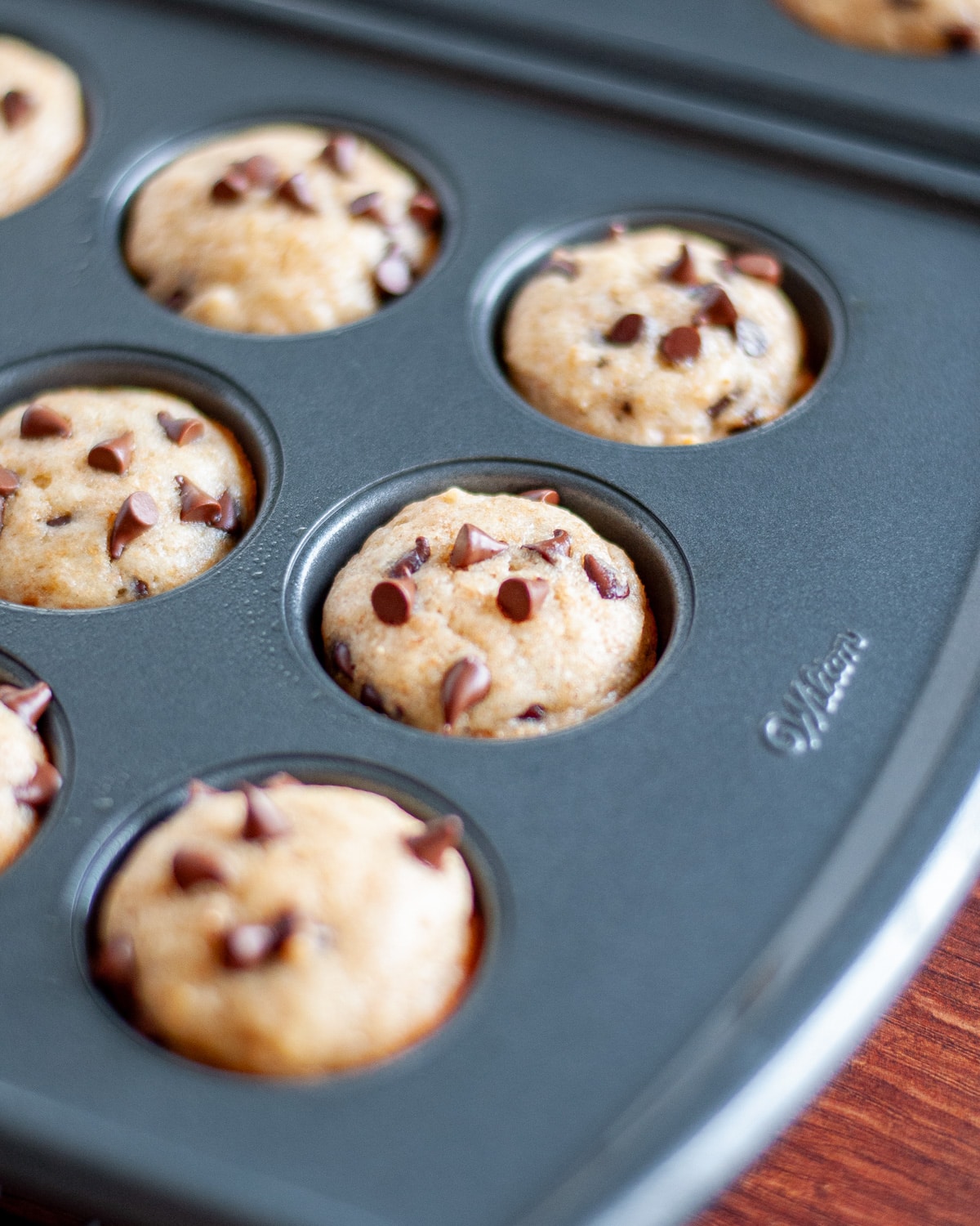 Close up of the baked mini chocolate chip muffins still in the tin.