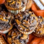 Close up of a basket of our swirled double chocolate pumpkin muffins, lined with an orange linen.