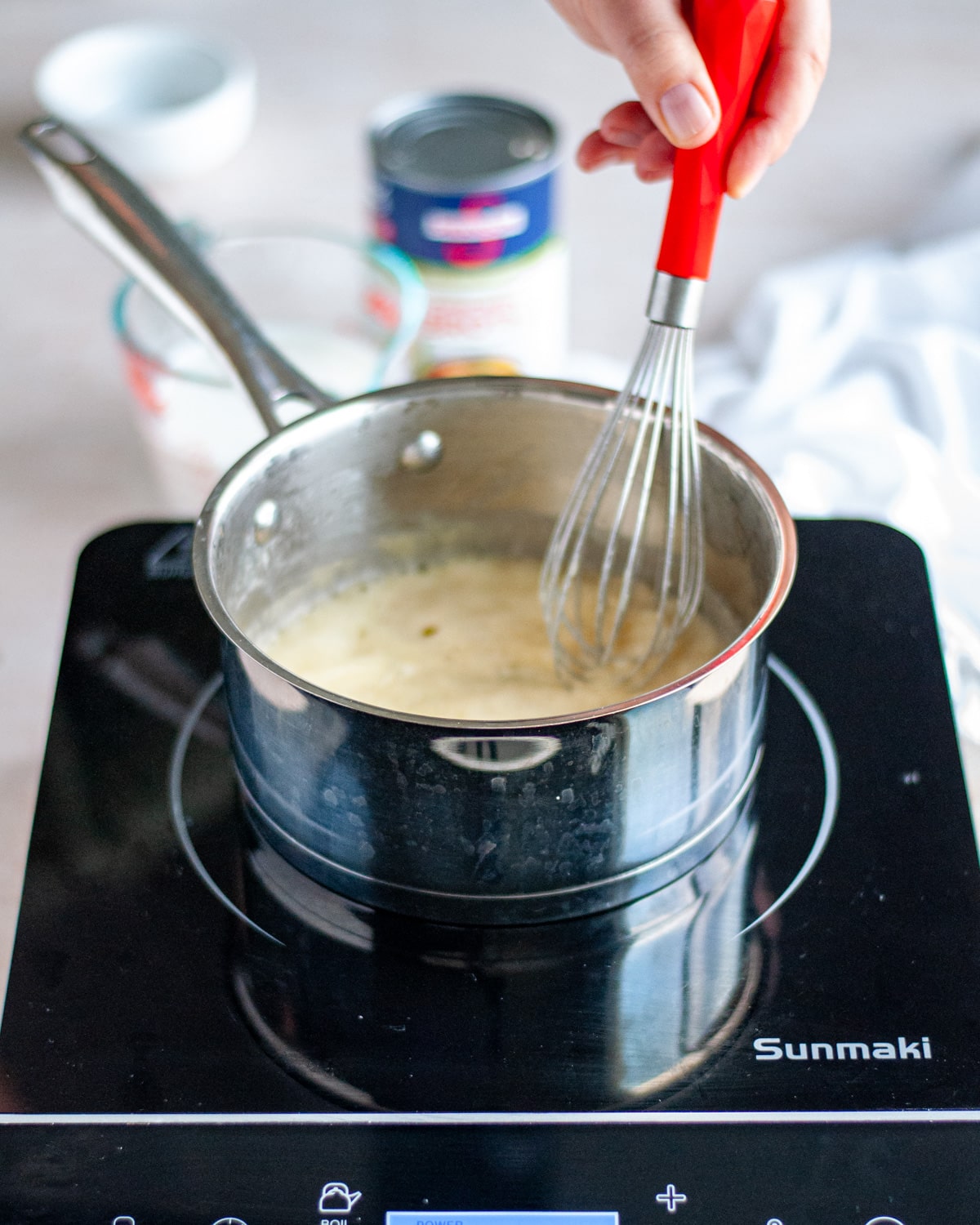Process shot showing flour whisked into the melted butter to create a roux.