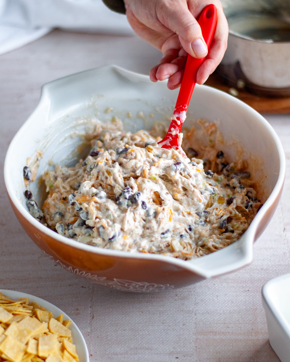 Process shot showing filling ingredients being stirred together in a large mixing bowl.