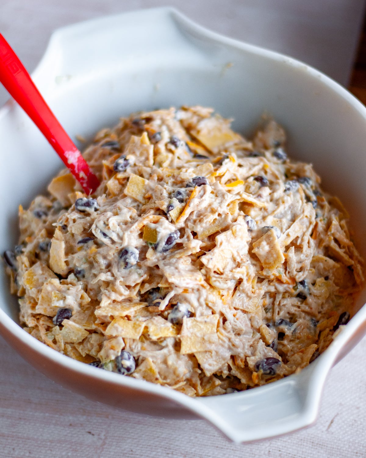 Close up of the chicken enchilada bake filling ingredients mixed together in a large bowl.