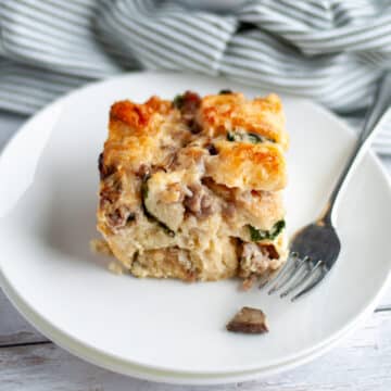 Feature image of our Close up of a slice of baked breakfast casserole with bread on a white serving plate.