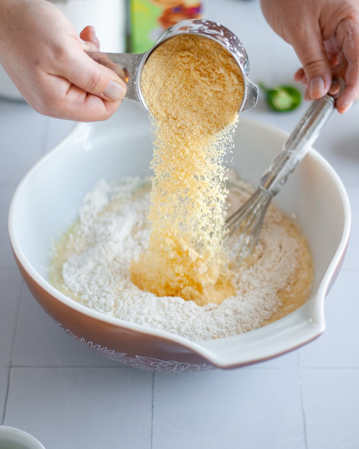 Process shot showing the corn meal being added into the mixing bowl.
