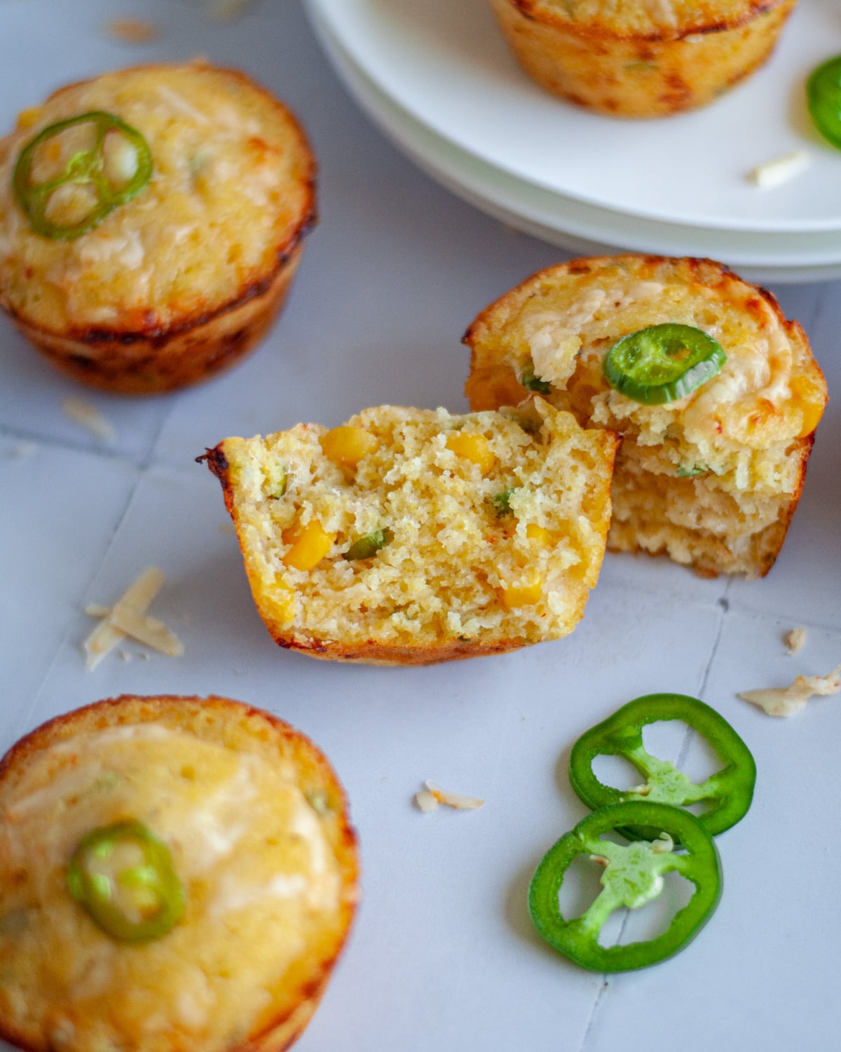 Close up of a savory cornbread muffin torn in half, showing the interior texture.