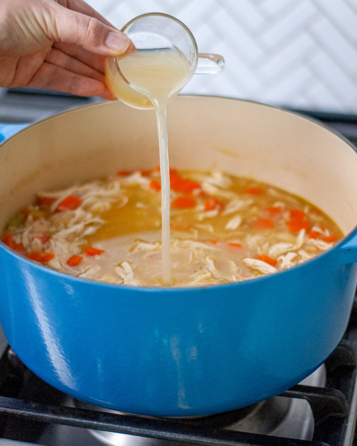 Process shot showing lemon juice being added to the soup.
