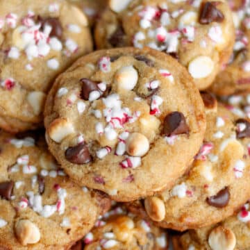 Feature image showing a up of a pile of peppermint chocolate chip cookies with candy cane pieces.