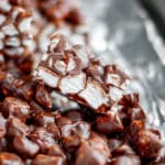 Close up of a square of rocky road, leaning onto the other cut squares on the baking sheet.