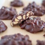 A whole bunch of chocolate peanut clusters, with the main focus showcasing the inside of a cluster.