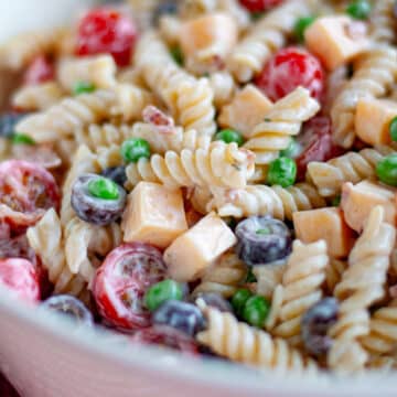 Feature image showing a close up of our bacon ranch pasta salad recipe in a white bowl.