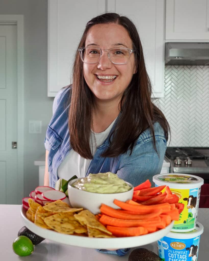 Meredith, creator of Our Love Language is Food, holding out a veggie tray with our creamy avocado dip in the center of it.