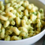 Close up of a white bowl of creamy zucchini pasta.